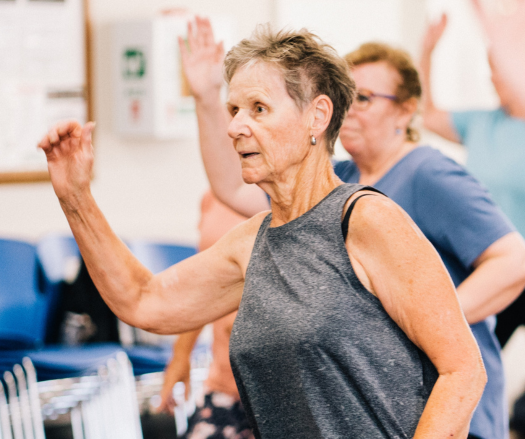 Dame âgée dans une classe d'exercices de groupe pour aînés